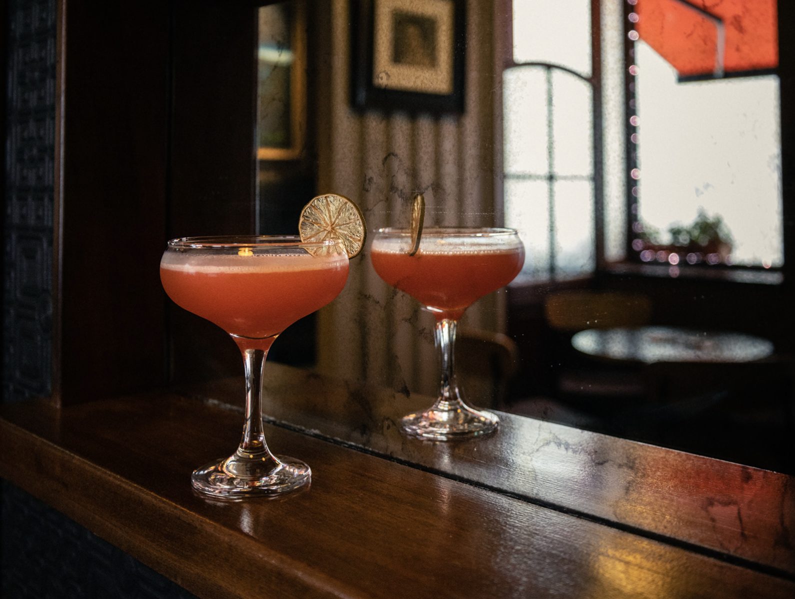 A cocktail reflected in the bar mirror