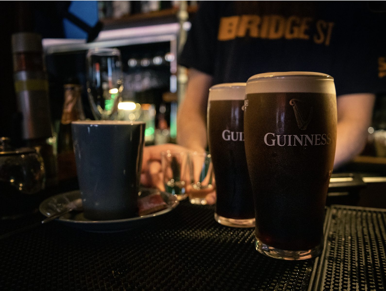 An espresso cup beside a settling pint of Guinness