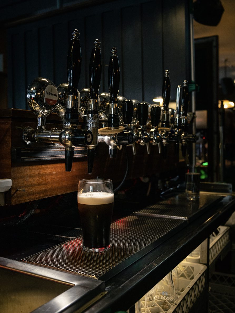A pint of Guinness settling under the taps