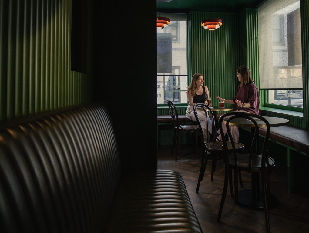 Two guests at the green window table